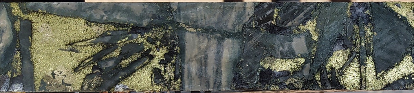 Typical sulphide-rich breccia mineralization in Hole 39: Tourmaline-sericite-chlorite altered siltstone clasts supported in a chalcopyrite-tourmaline-pyrite matrix. SFDH-039, 456.8m. From a 1m sample that averaged 0.82 g/t gold, 127 g/t silver and 4.8% copper. Photograph is of a selected interval and is not necessarily representative of mineralisation hosted throughout the property.