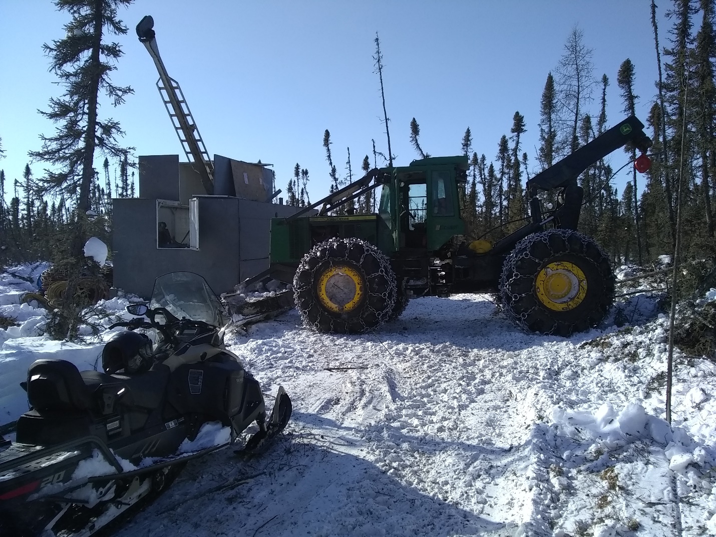 A photograph of the crew mobilizing the diamond drill rig in snow.