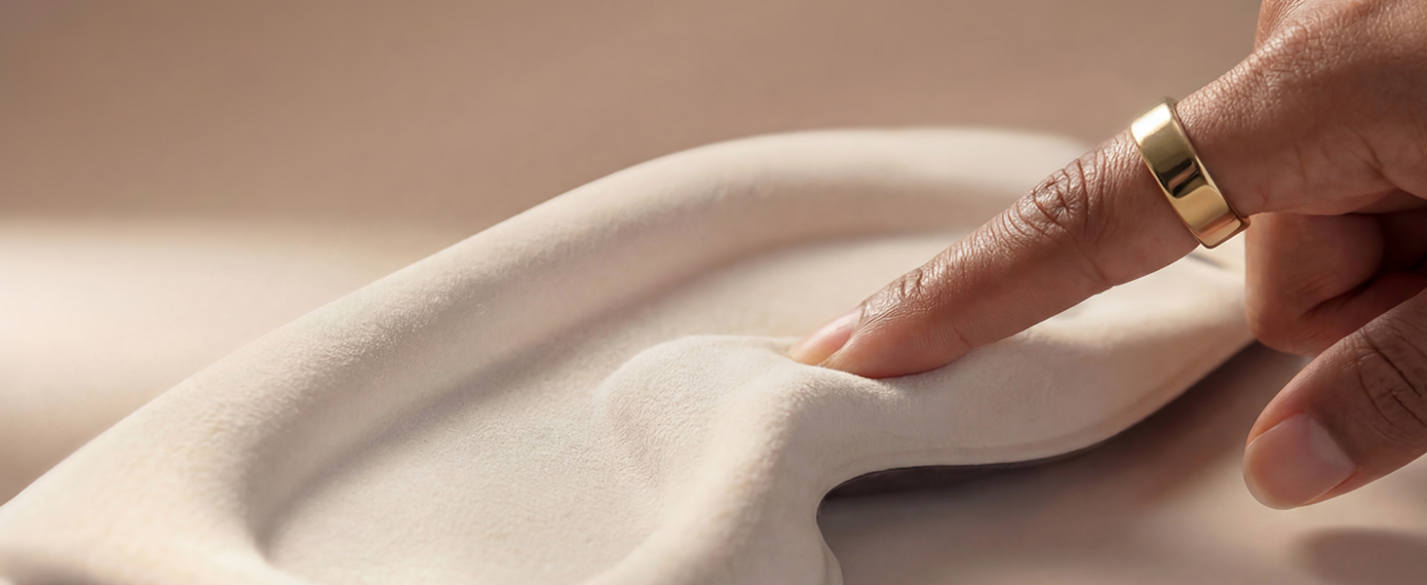 A finger touching the soft, skin-friendly inner lining material of the Sleenova sleep mask.