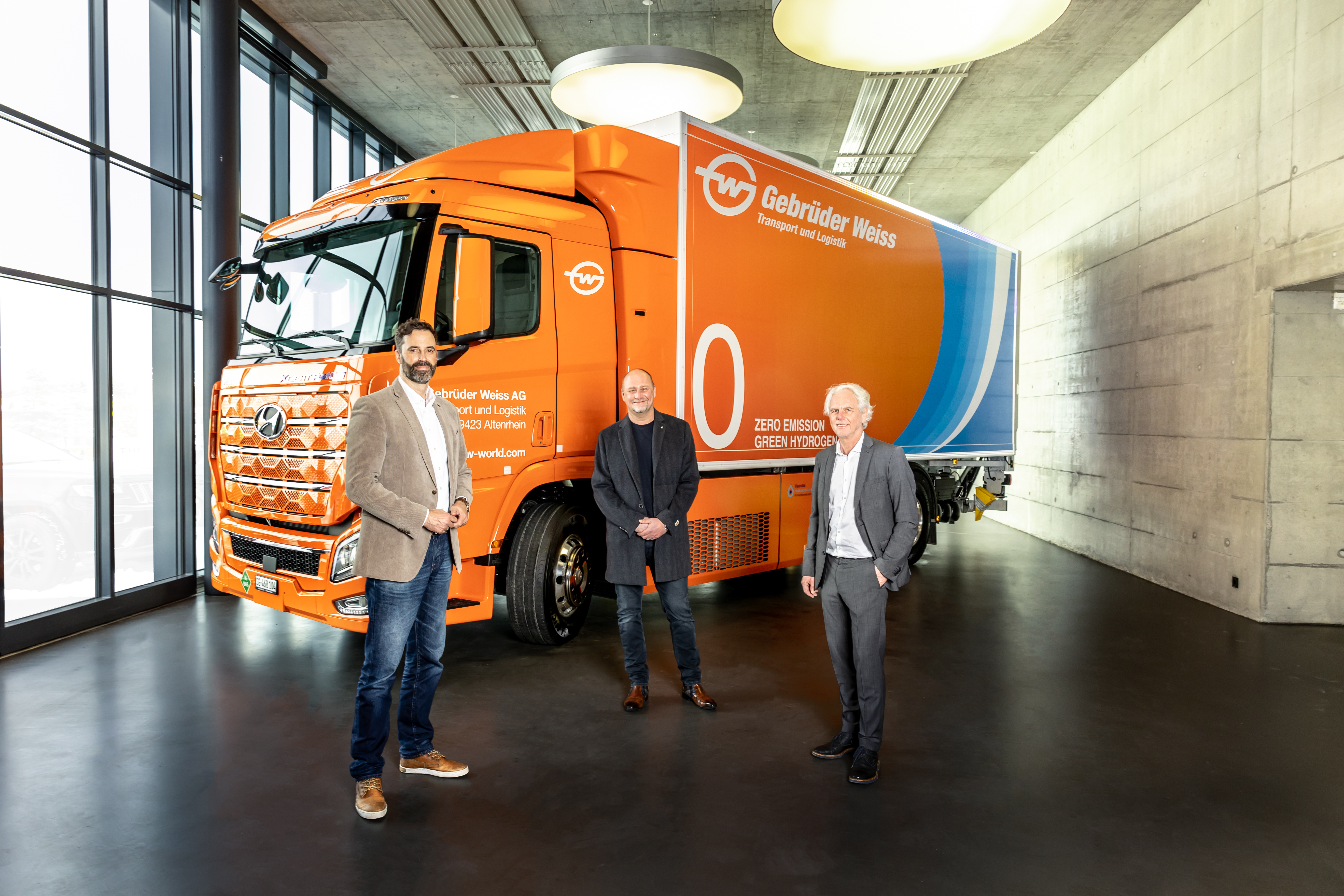 At the handover of the hydrogen truck in Rothenburg, Switzerland (from the left): Marc Freymüller, CEO Hyundai Hydrogen Mobility AG, Peter Waldenberger, Head of Corporate Administrative Support, and Oskar Kramer, Country Manager Switzerland (both Gebrüder Weiss). 
(Source: Gebrüder Weiss / Stefan Peter)
