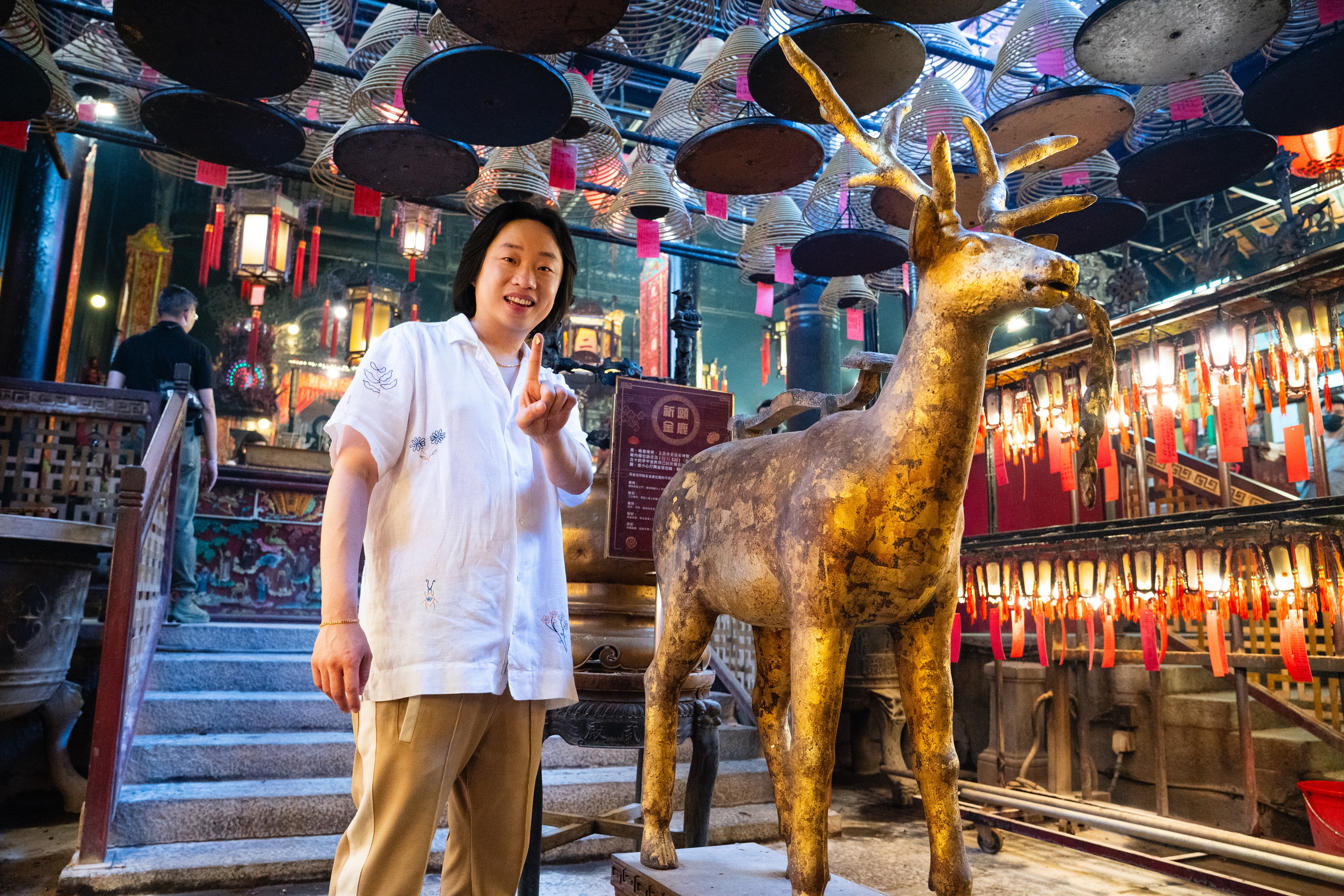 Jimmy applies gold foil to the Golden Deer at Man Mo Temple