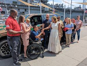 Wounded Warriors Family Support CEO and President Kate McCauley (front right) presents the keys to Luis Remache's (center) 2022 Ford F-150 mobility-equipped vehicle Friday morning.