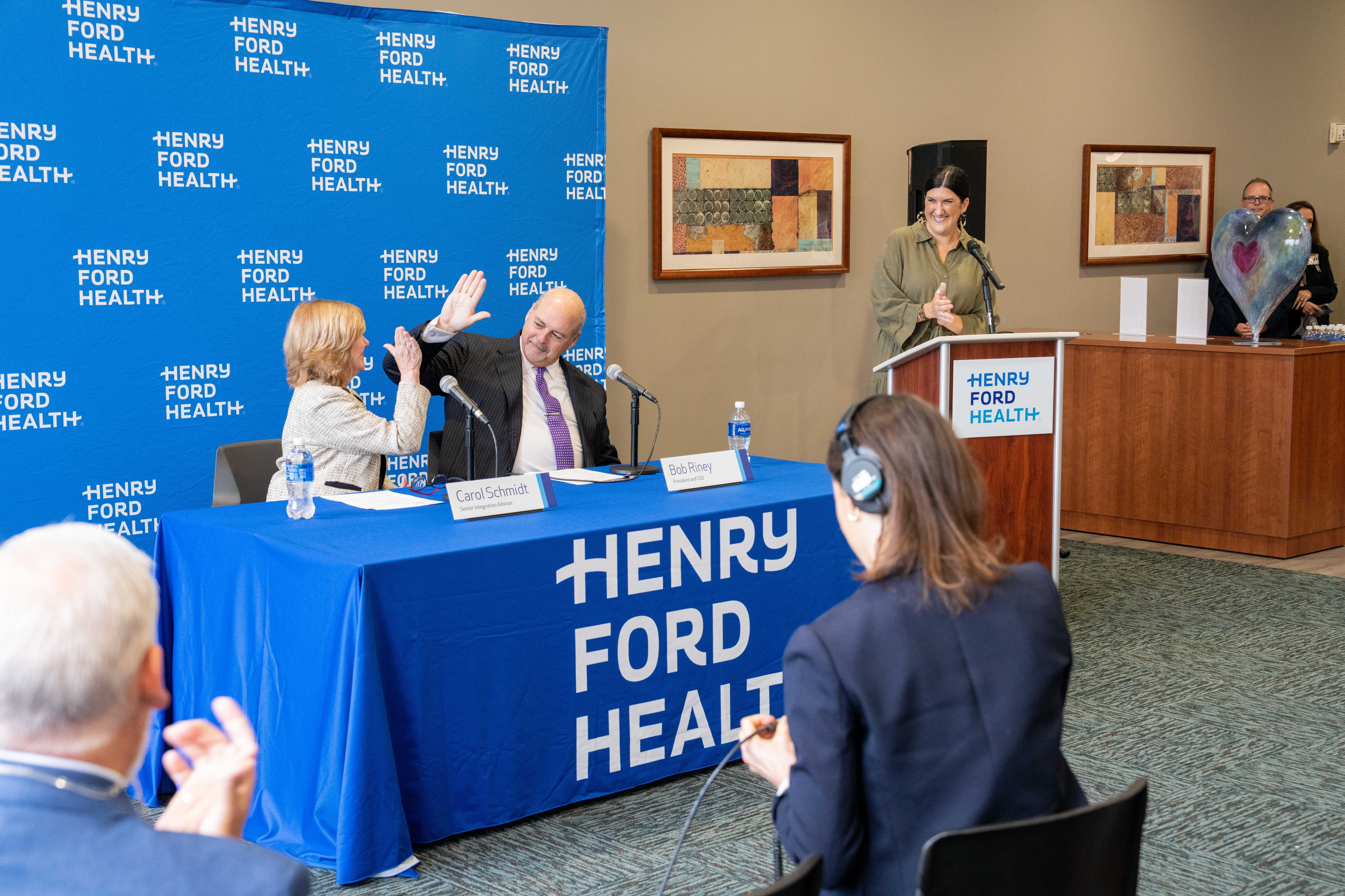 Henry Ford Health President & CEO Bob Riney and Carol Schmidt, Senior Vice President, Ascension & Senior Integration Advisor, Henry Ford Health, celebrate after taking questions from the media on Day 1 of a joint venture between Henry Ford Health and Ascension Michigan. The newly formed organization is branded Henry Ford Health and continue to be headquartered in Detroit. Riney will lead the organization that will include 13 acute care hospitals in Michigan.