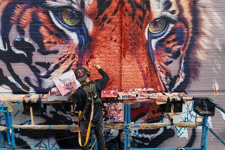Sonny Sundancer paints tiger mural in New York City
