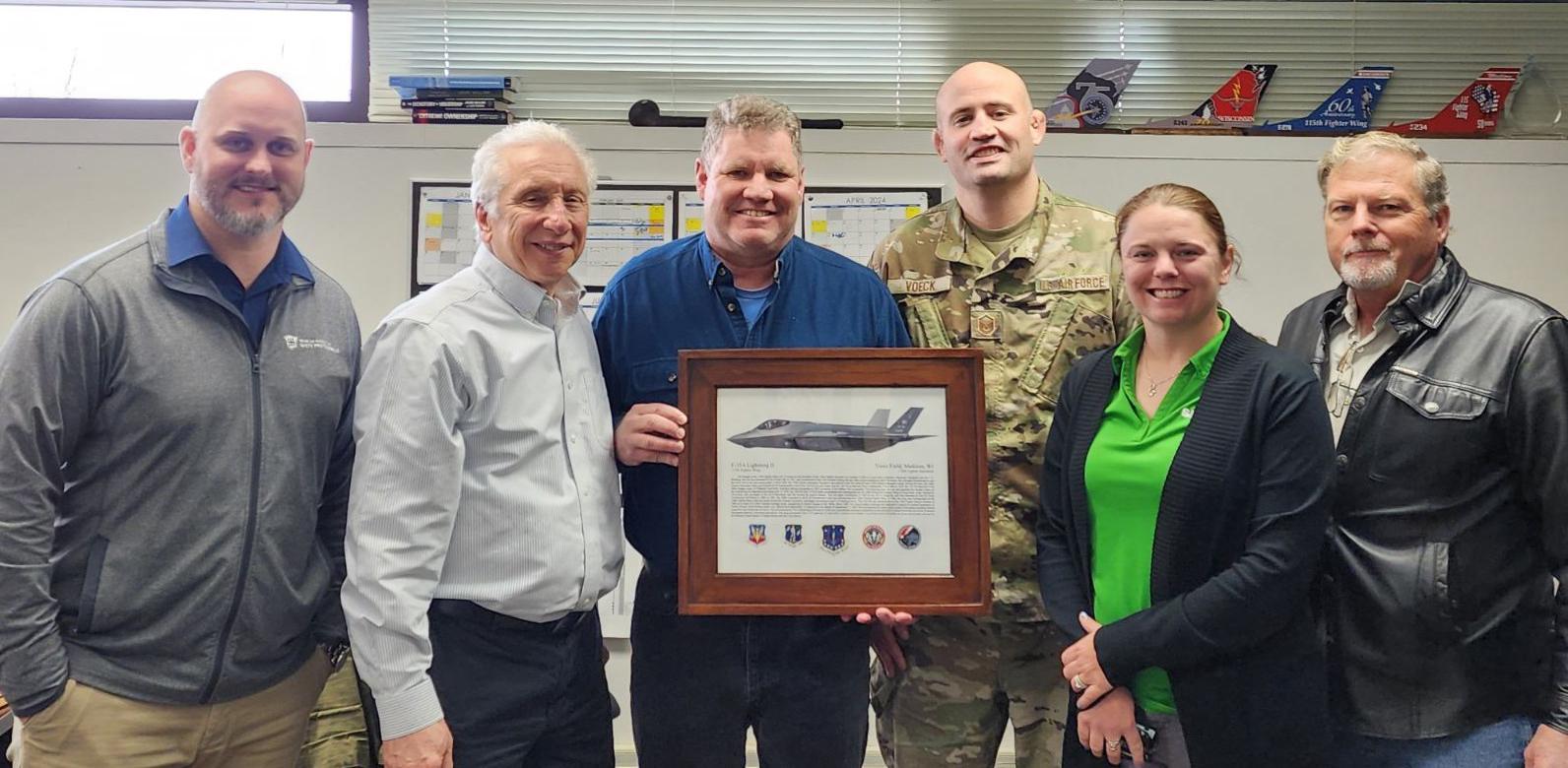 CMSgt Tom Egstad and MSgt Karl Voeck (center) presented a placard of appreciation from the 115th Fighter Wing to (left to right) CTC’s Brandon Hody, Ed Jerome, Lori Schroth, and Bill Leipprandt during their SMCX assessment of the site in February 2024.