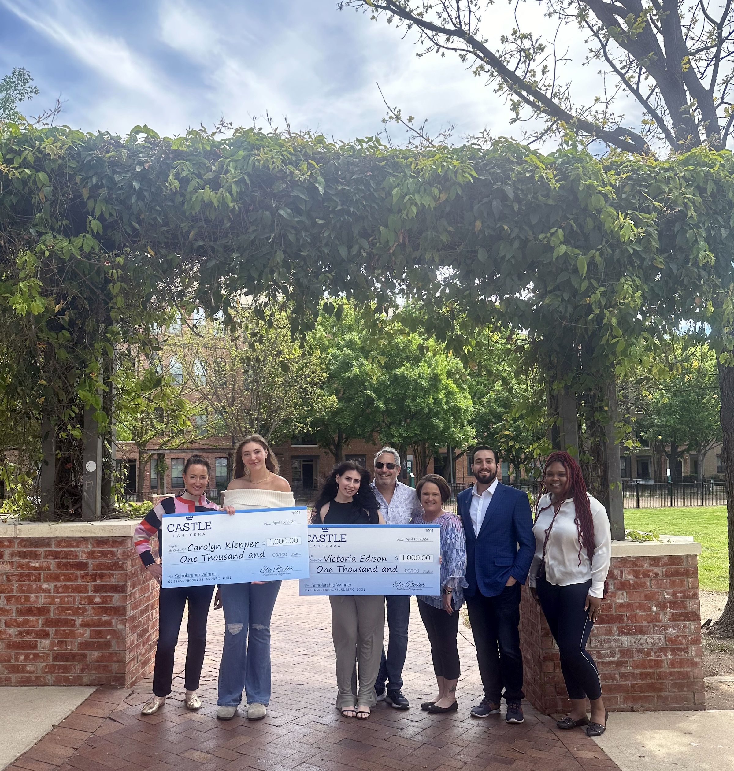 Victoria Edison (University of Delaware) and Carolyn Klepper (University of Texas at Austin), residents of Castle Lanterra’s The Residences at Triangle in Austin, TX, accept their 2024 scholarships along with their parents and staff of the property. (Photo Courtesy of Castle Lanterra)