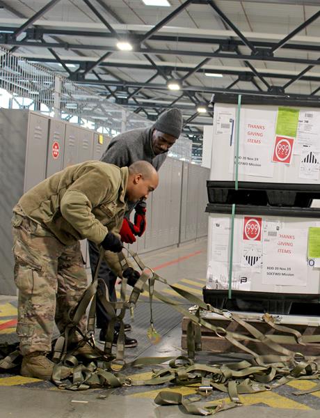 Greg Turner, DLA Troop Support Europe & Africa customer support specialist, works with Air Force Staff Sgt. Keith Cooper-Griffin, 721st Aerial Port Squadron, to prepare a pallet of Thanksgiving food items Nov. 20 at Ramstein Air Base, Germany, to be flown to service members in Africa. Customer support teams at DLA Troop Support Europe & Africa helped ensure service members throughout the region had a taste of home for the holidays by providing Thanksgiving meals. 