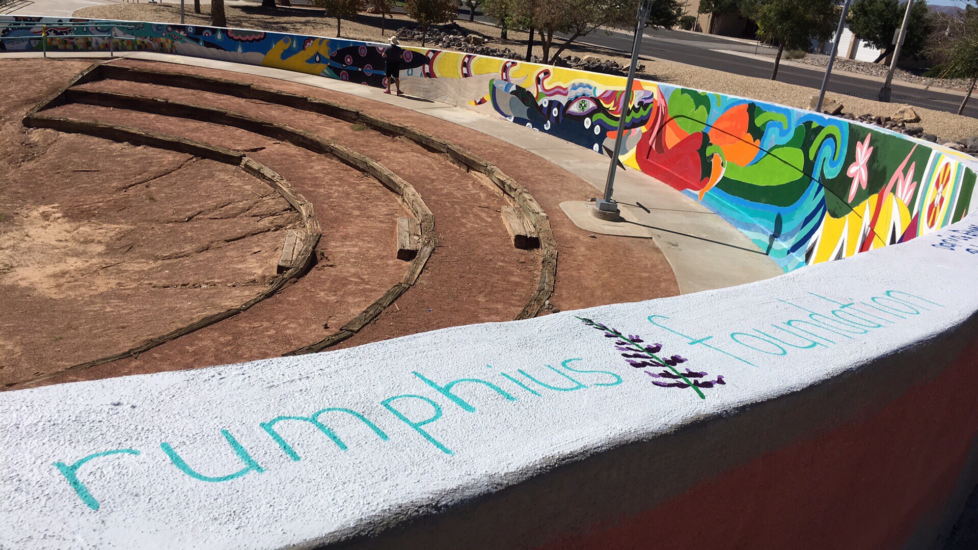 The Rumphius Foundation logo painted on the wall of the collaborative mural led by Cruces Creatives, celebrating the diversity and agricultural roots of the New Mexico community. 