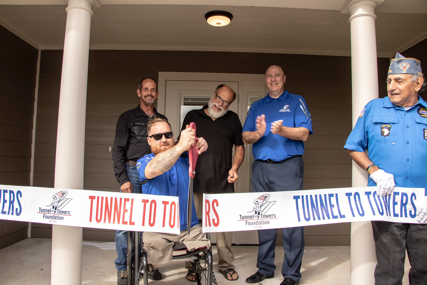 U.S. Army SPC Terence ‘Bo’ Jones cuts a ribbon outside of his new mortgage-free smart home. 