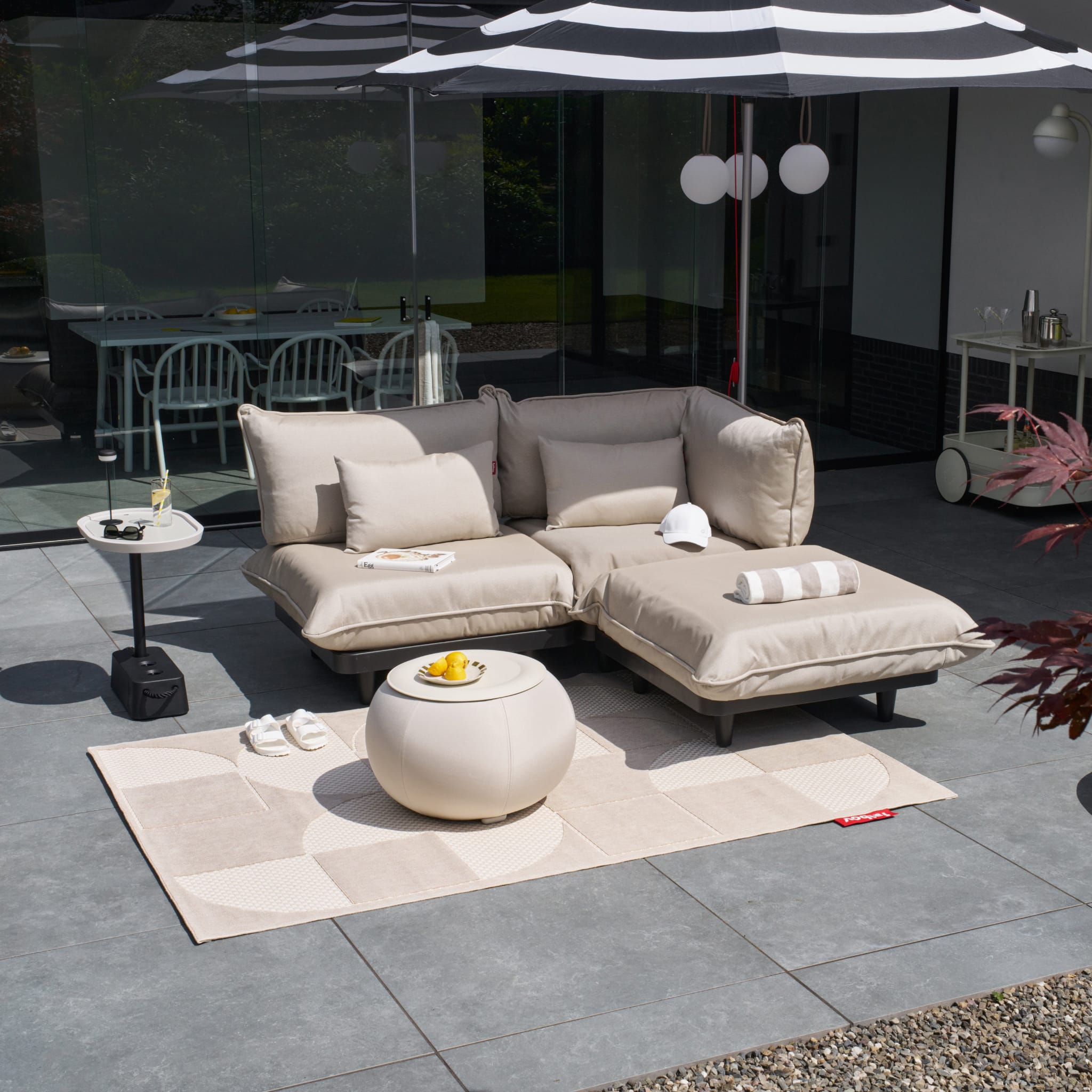Canapé d'extérieur 3 places Fatboy Paletti, avec coussins modulables et table basse, sur une terrasse moderne.