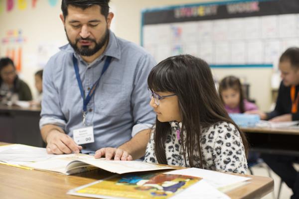 Photo of a students and volunteer tutor in a reading center engaging in Reading Partners’ traditional tutoring program (Photo Credit: Reading Partners)
