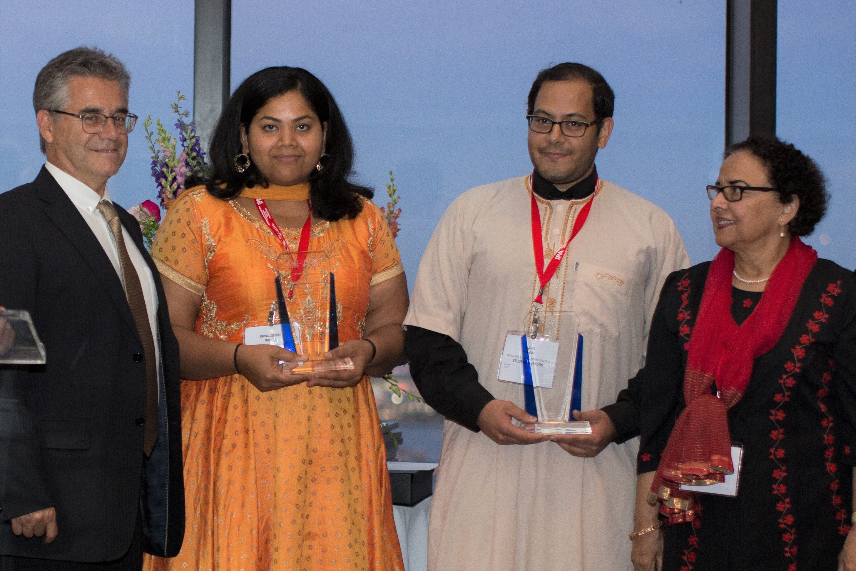 Dr. Srivalleesha Mallidi (center-left) and Dr. Girgis Obaid (center-right) receiving 2019 Early Investigator Awards from IPA President, Dr. Luis Arnaut (left) and IPA Past-President, Dr. Tayyaba Hassan (right).