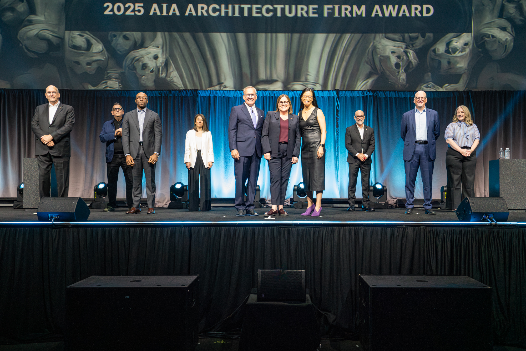 People on a convention center stage receive an award.