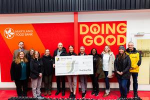 Sandy Spring Bank volunteers at the Maryland Food Bank. Check presentation photo in front of Maryland Food Bank signage in the warehouse. 