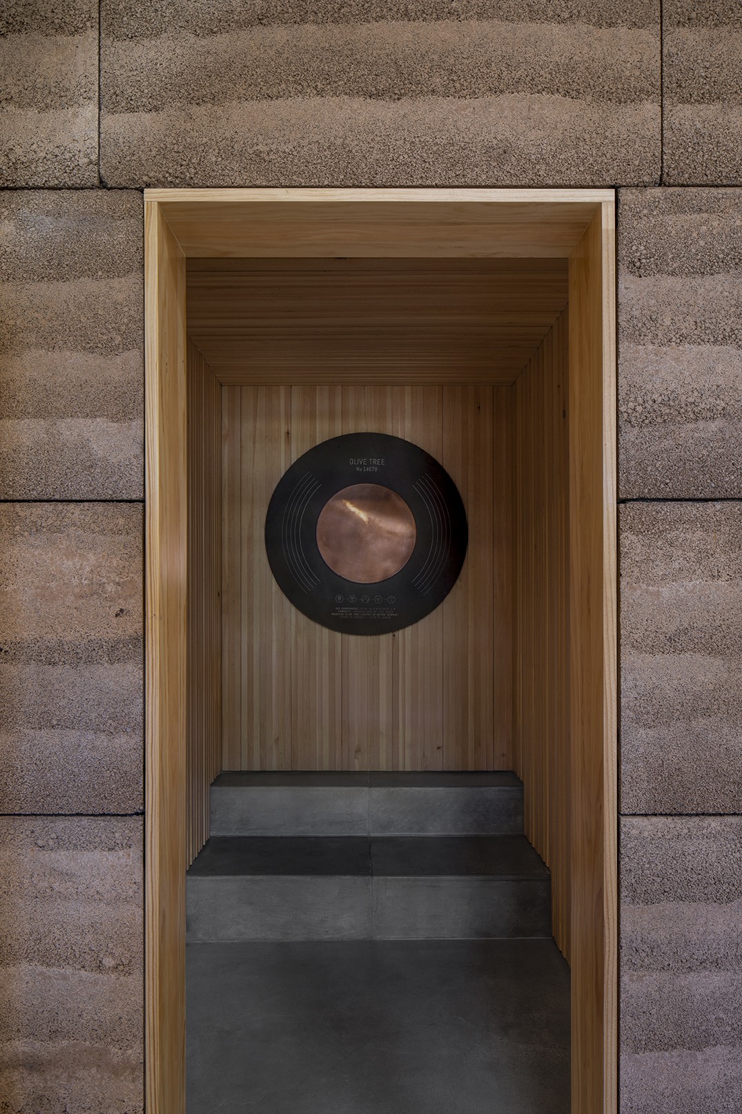 Olive re:connect, the Frequency Room at the heart of OLIVE TREE PEOPLE’s first U.S. flagship, sits within the rammed-earth architecture of its “cathedral to Waterless Beauty,” creating a space dedicated to experiencing the frequencies of the olive tree.