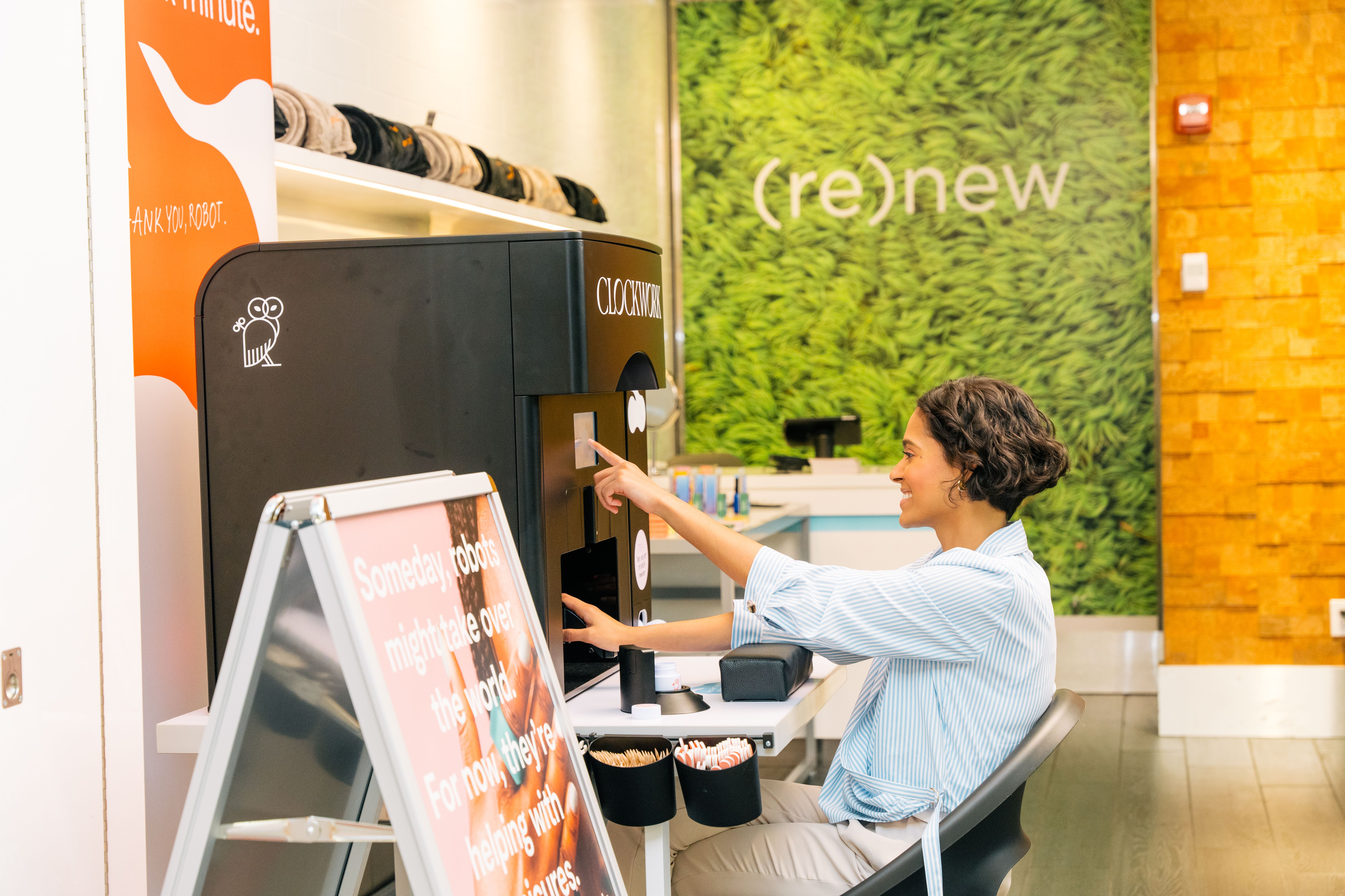 Woman using Clockwork's robotic MiNiCURE at XpresSpa at JFK Airport's Terminal 4