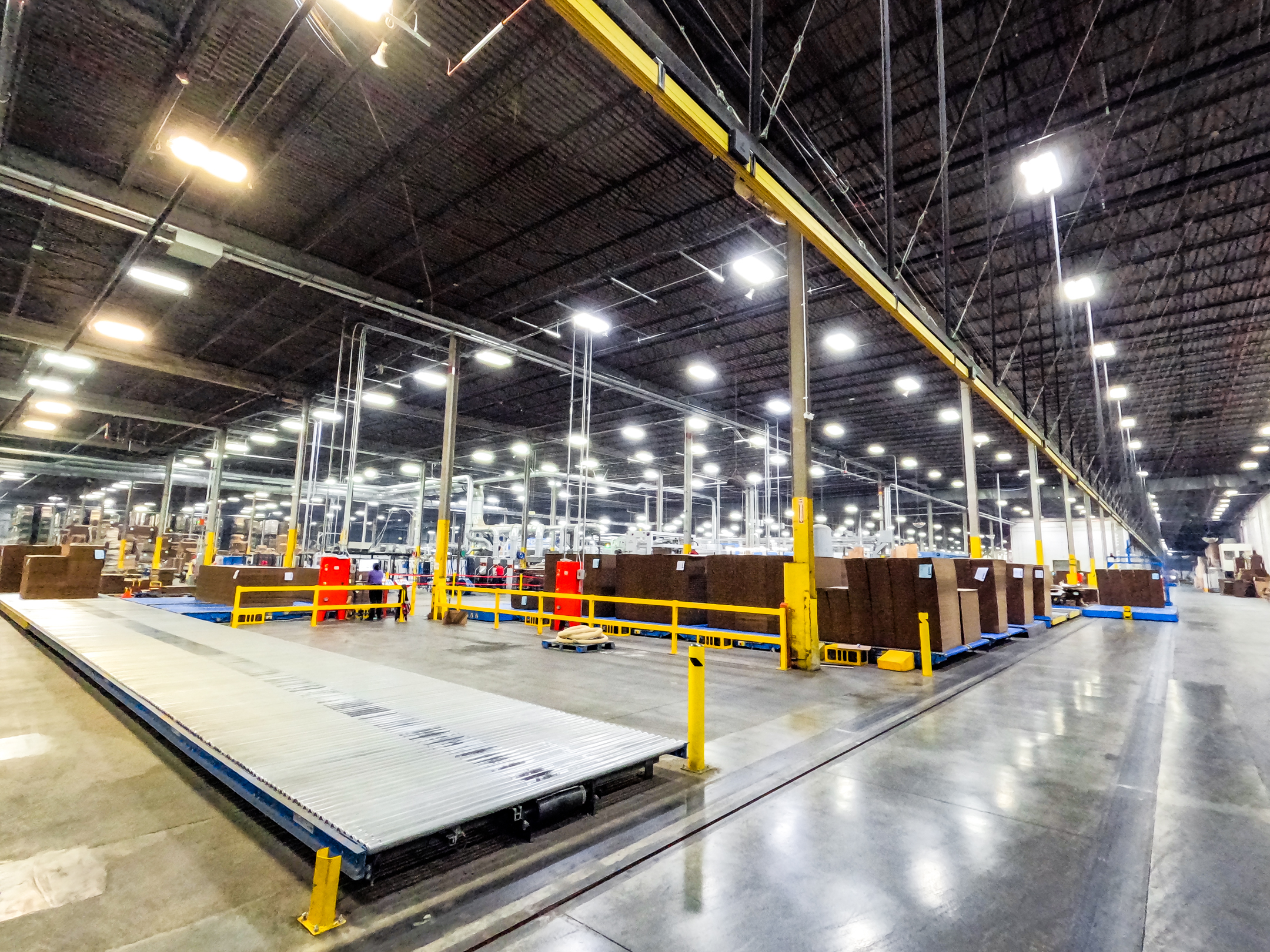Wide-angle view of the corrugated box manufacturing floor at President Container Group's Middletown NY Super Plant, showing automated conveyor systems
