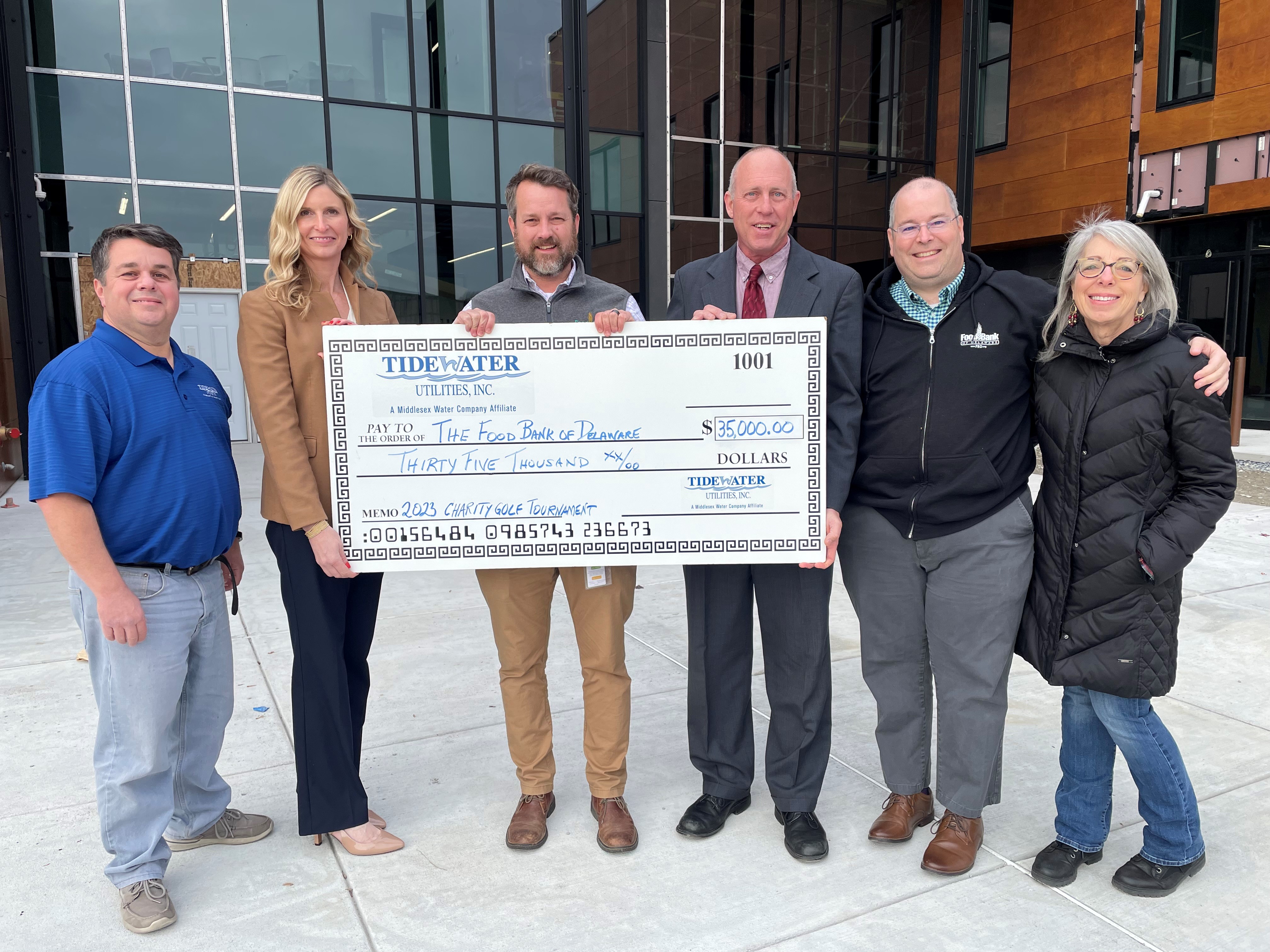 TIDEWATER TEAM DELIVERS HOLIDAY CHEER AND PRESENTS CHARITY OUTING PROCEEDS: (Pictured Left to Right)  Joseph Cuccinello, Tidewater CPCN Coordinator and Event Organizer, Kirsten E. Higgins, Vice President, Tidewater Utilities; Larry Haas, Chief Development Officer – Food Bank of Delaware; Bruce E. Patrick, President, Tidewater Utilities; Chad Robinson Director of External Affairs, Food Bank of DE and Susan DeNardo, Community Development Manager, Food Bank of DE.