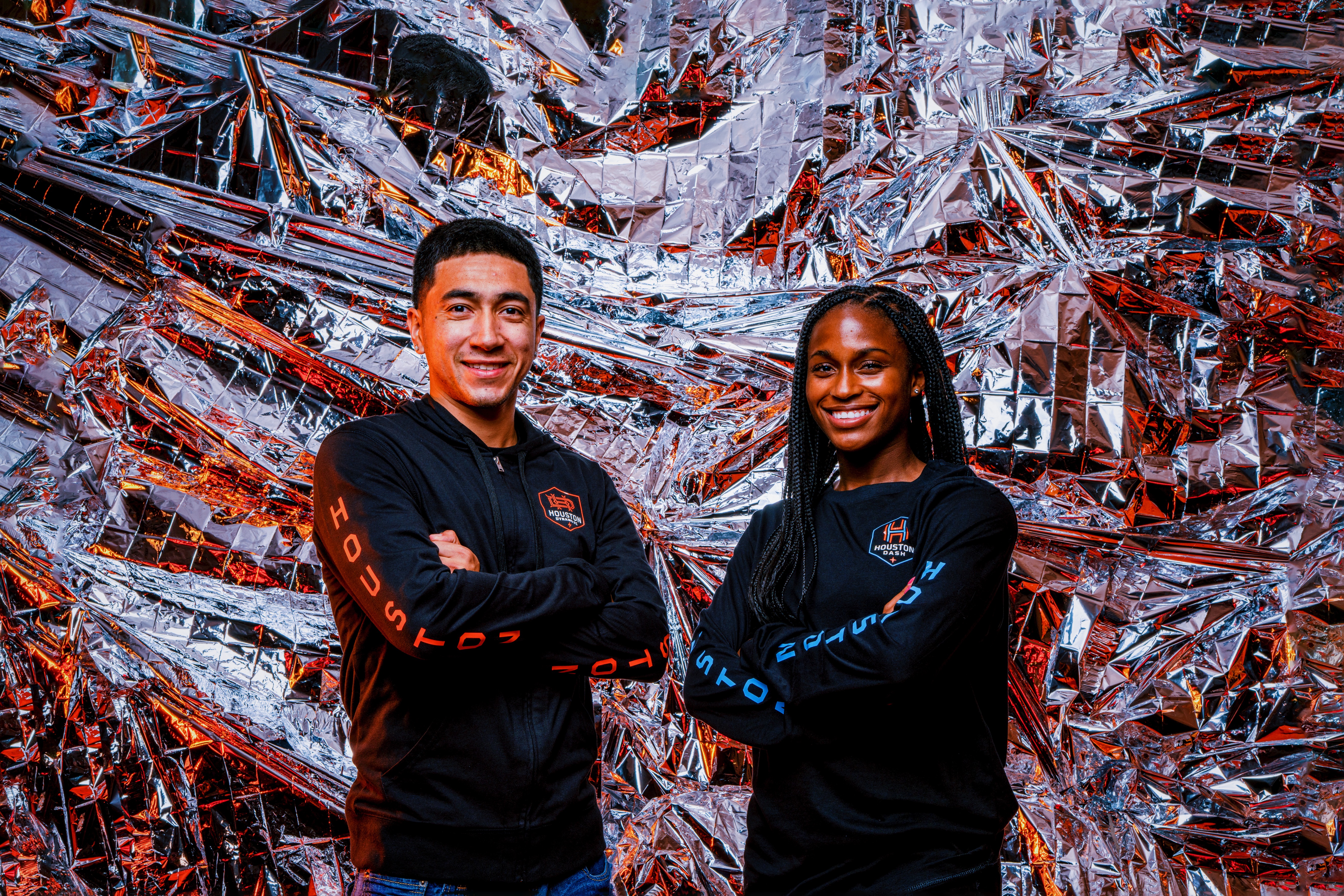 Houston Dynamo Football Club midfielder Memo Rodriguez and Houston Dash forward Nichelle Prince pose at BBVA Stadium. Both players are wearing the new Houston Dynamo FC and Dash merchandise available to fans at HoustonDynamoFC.com