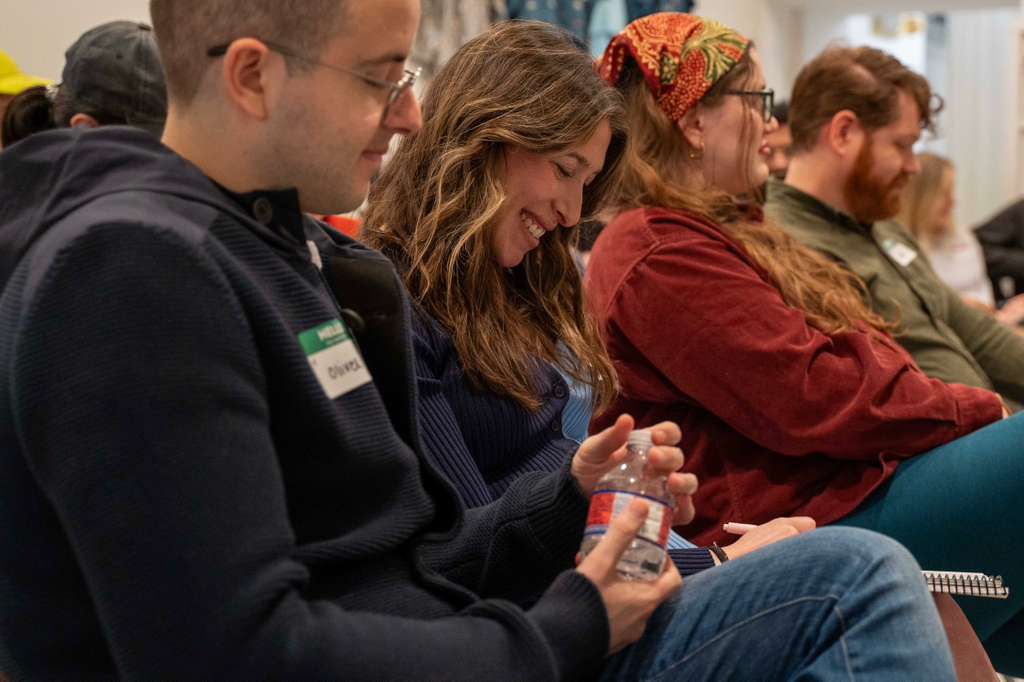Expecting parents listening and smiling during a clinician-led prenatal education session.