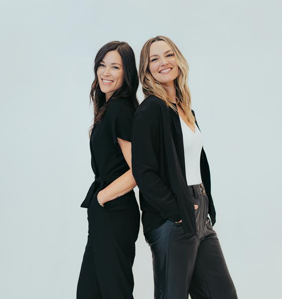 Image of Kelly Oriard and Callie Christensen, co-founders of Slumberkins, standing back to back