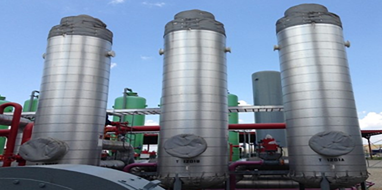 three large vertical metal tanks