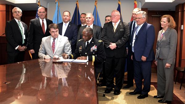 Defense Logistics Agency Director Army Lt. Gen. Darrell Williams (seated, right) signs an interagency agreement between DLA and the Department of Veterans Affairs with VA Secretary Robert Wilkie (seated, left) at the VA Headquarters in Washington, D.C., Aug. 12.