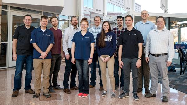 Members of the Space Dynamics Laboratory HARP team pose for this photo on February 19, 2020, at SDL’s headquarters in North Logan, Utah, the day HARP was deployed from the International Space Station. Pictured from left to right are Bryan Hansen, Camren Hansen, Jaden Miller, Matt Jeppesen, Hannah Brailsford, Jason Hansen, Jenny Hinton, Cameron Weston, David Allen, Ryan Martineau, and Tim Neilsen. (Credit: Ben Sharp/Space Dynamics Laboratory)