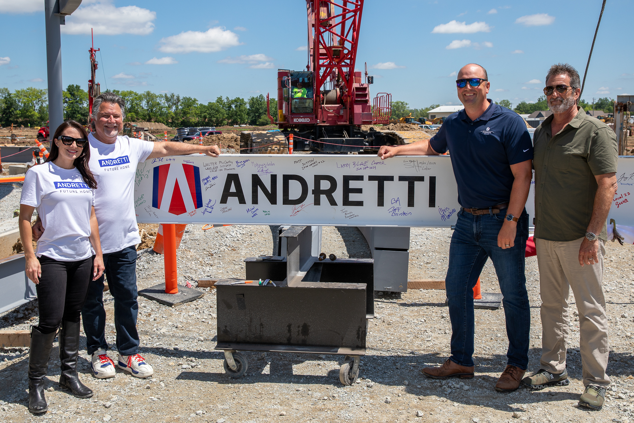 (From left) Andretti Global Vice President / Andretti Technologies Managing Director Marissa Andretti, Andretti Global Chairman & CEO Michael Andretti, Mayor of Fishers, Indiana Scott Fadness, and Bradford Allen Principal & Co-Founder Jeffrey Bernstein join Clark Construction in raising the final beam to top out the new Andretti Global headquarters in Fishers, IN.