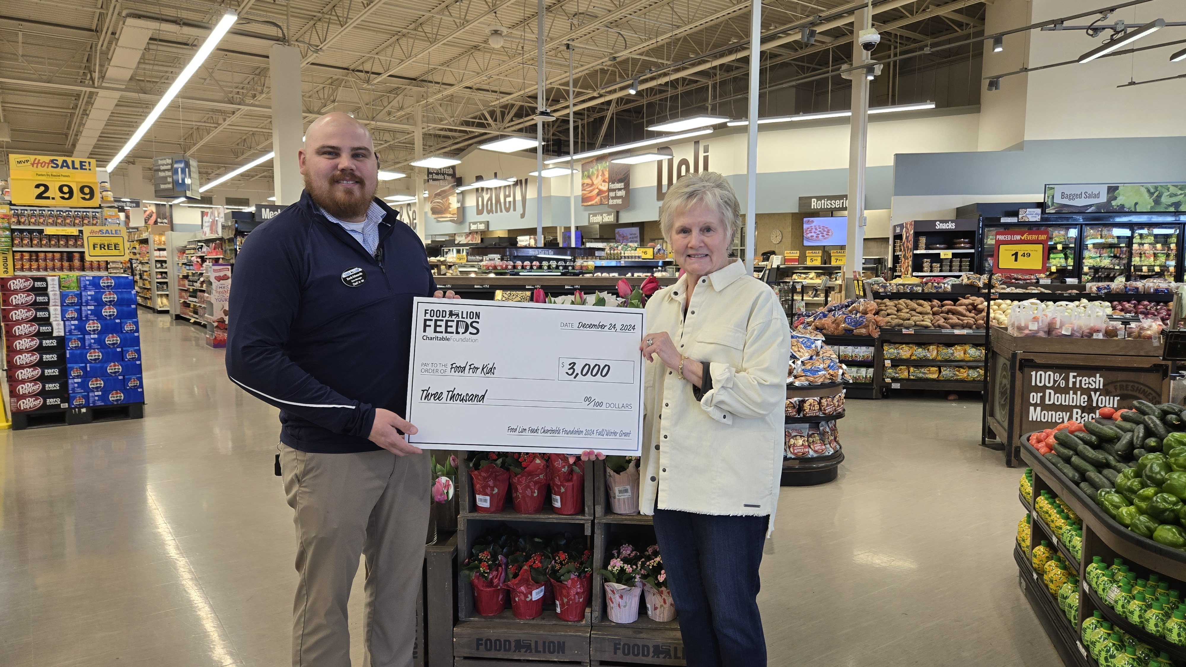  Food Lion Store Manager Zach Edwards and Susan Tinsley of Food for Kids.