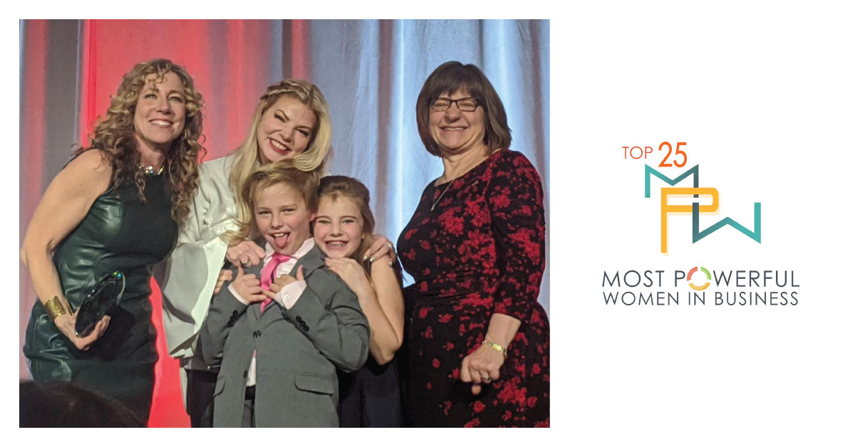 Nancy Fitzgerald with her two children, ages 9 and 12, accepting the Top 25 Most Powerful Women in Business award from Kristen Blessman, CEO of the Colorado Women's Chamber of Commerce, and Laurie Muller Girard, EVP, Western Region for Keybank.