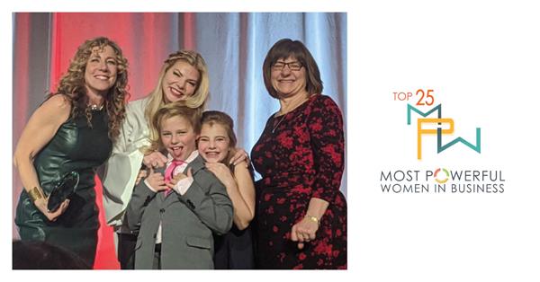 Nancy Fitzgerald with her two children, ages 9 and 12, accepting the Top 25 Most Powerful Women in Business award from Kristen Blessman, CEO of the Colorado Women's Chamber of Commerce, and Laurie Muller Girard, EVP, Western Region for Keybank.