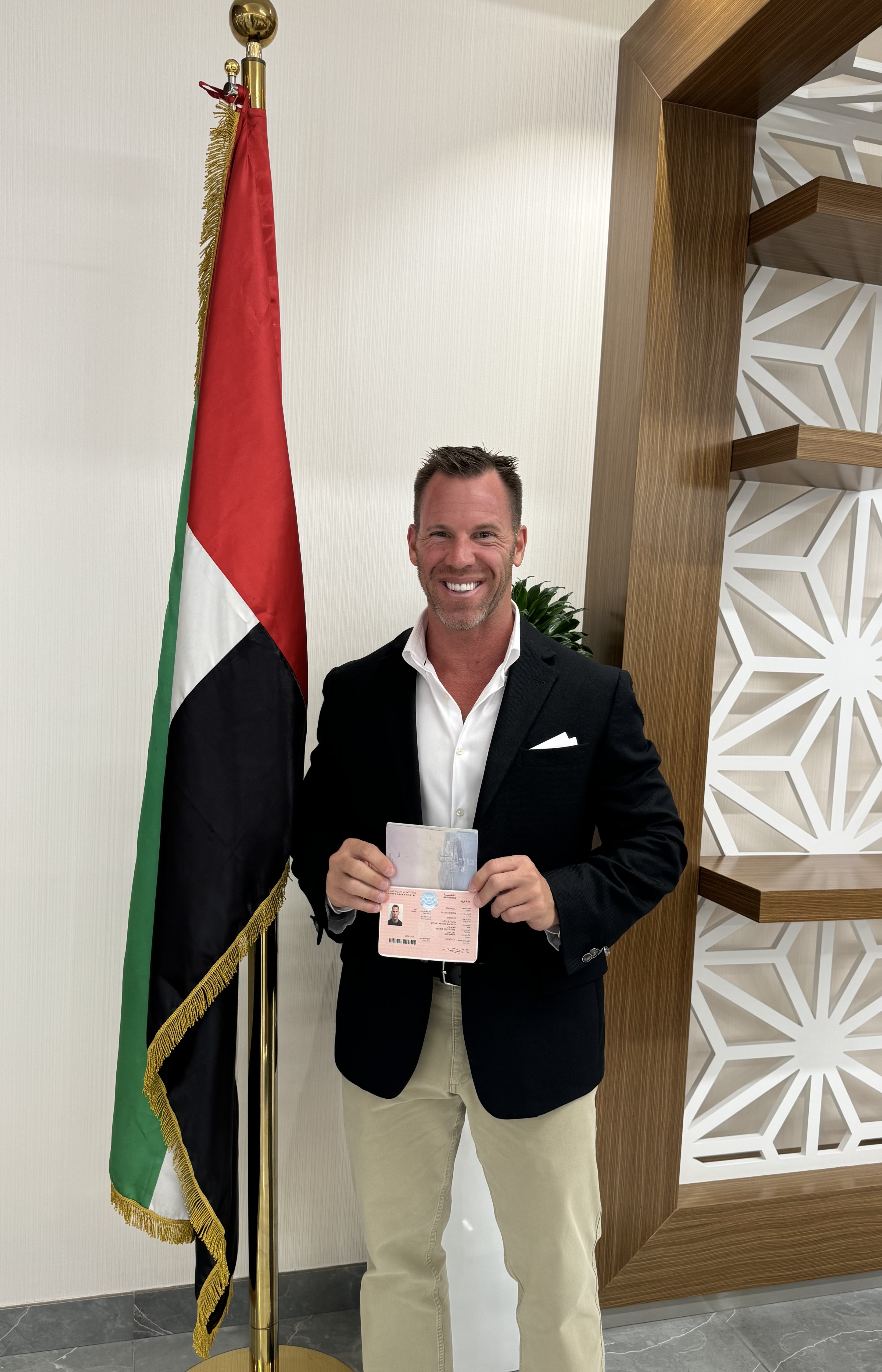 Nano Hearing Aids CEO Zackon Next to UAE Flag with Golden Visa