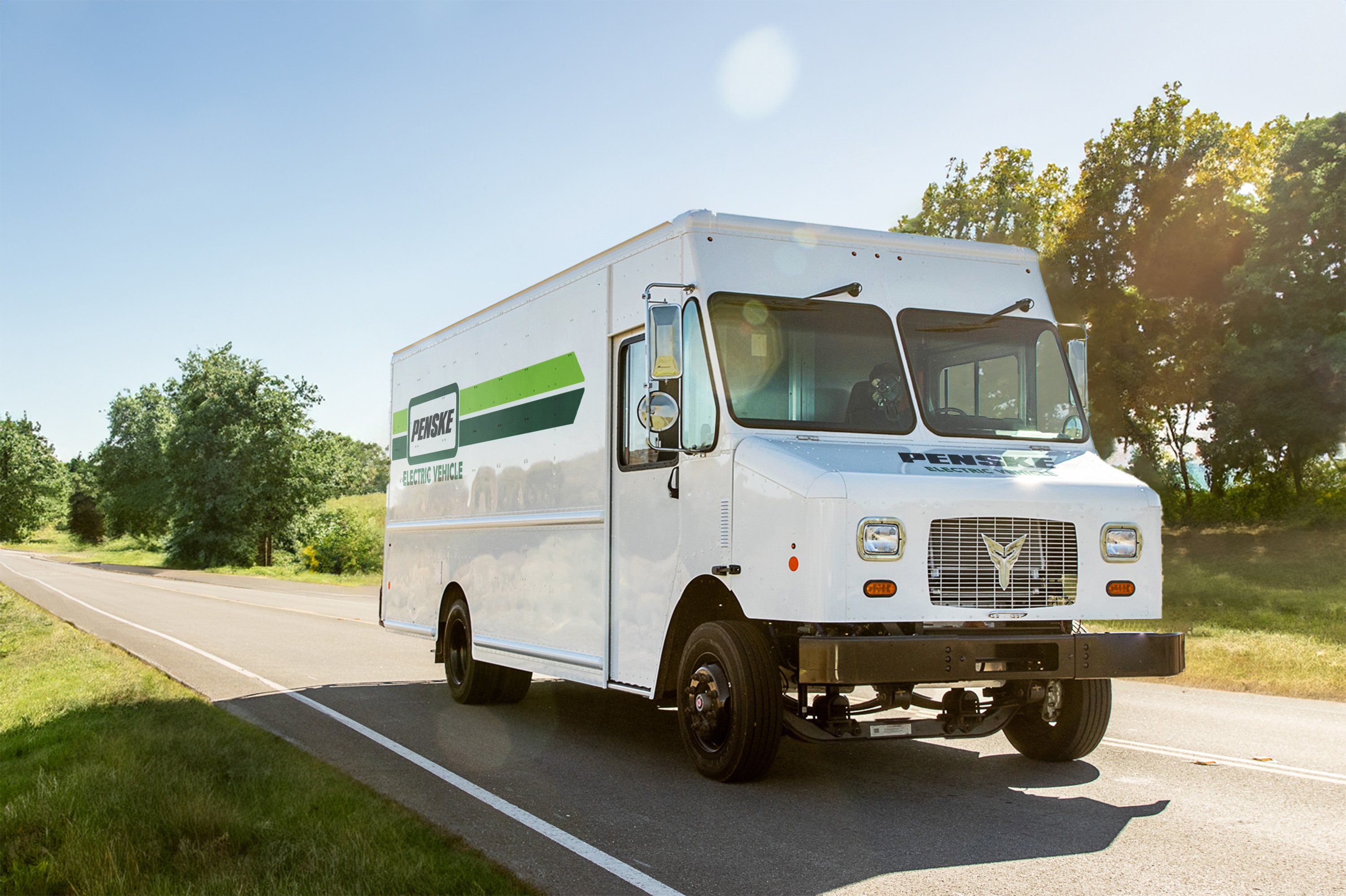 Penske Branded Stepvan Driving on a Treelined Street