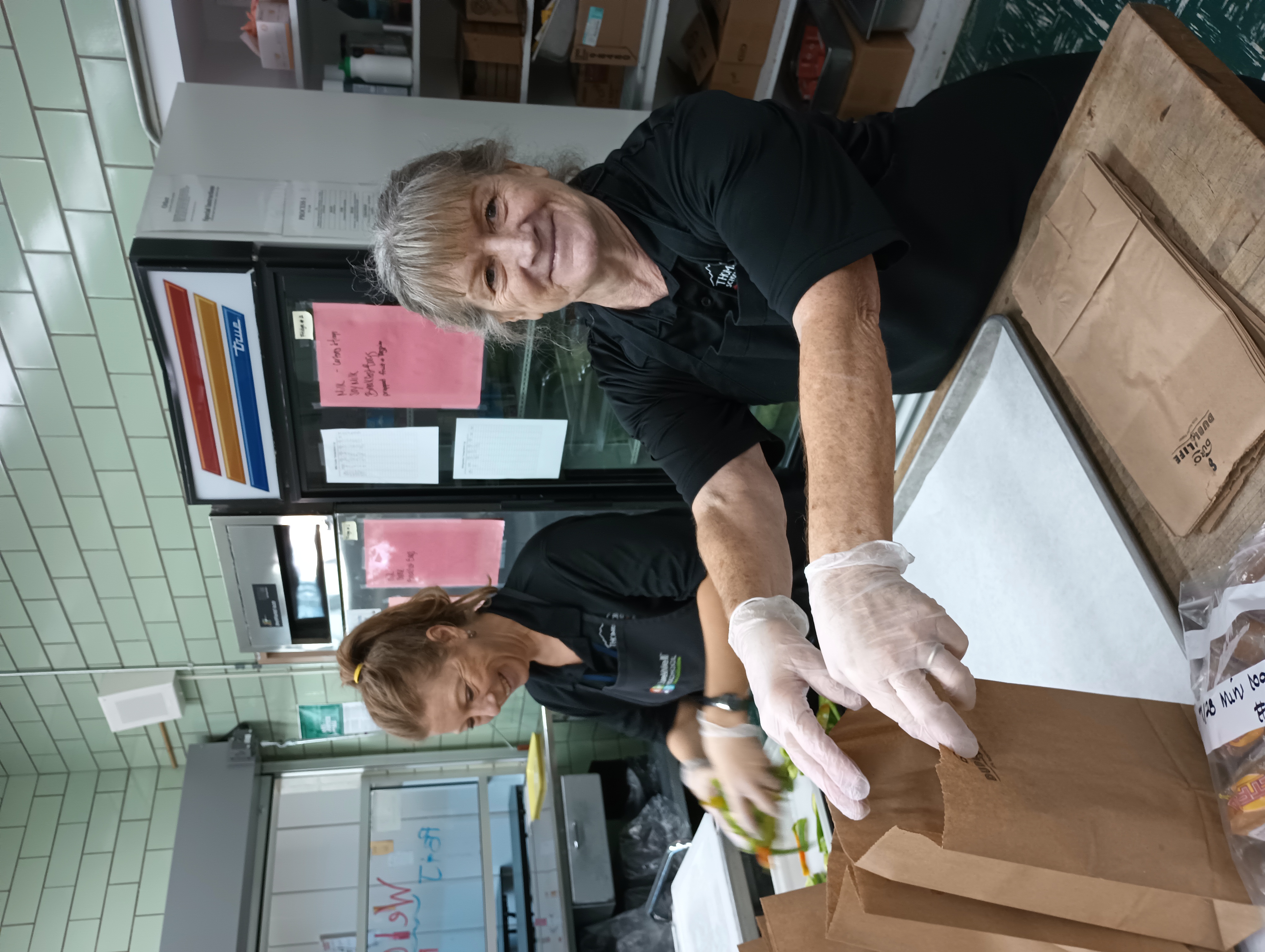 Two nutrition services workers in a cafeteria in the Thompson School District serving healthy lunches