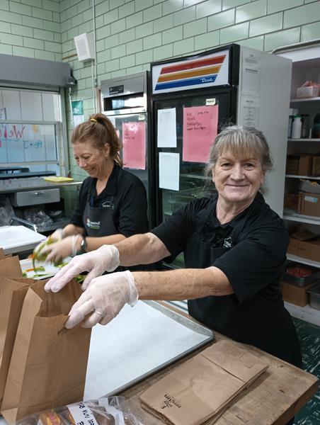 Two nutrition services workers in a cafeteria in the Thompson School District serving healthy lunches