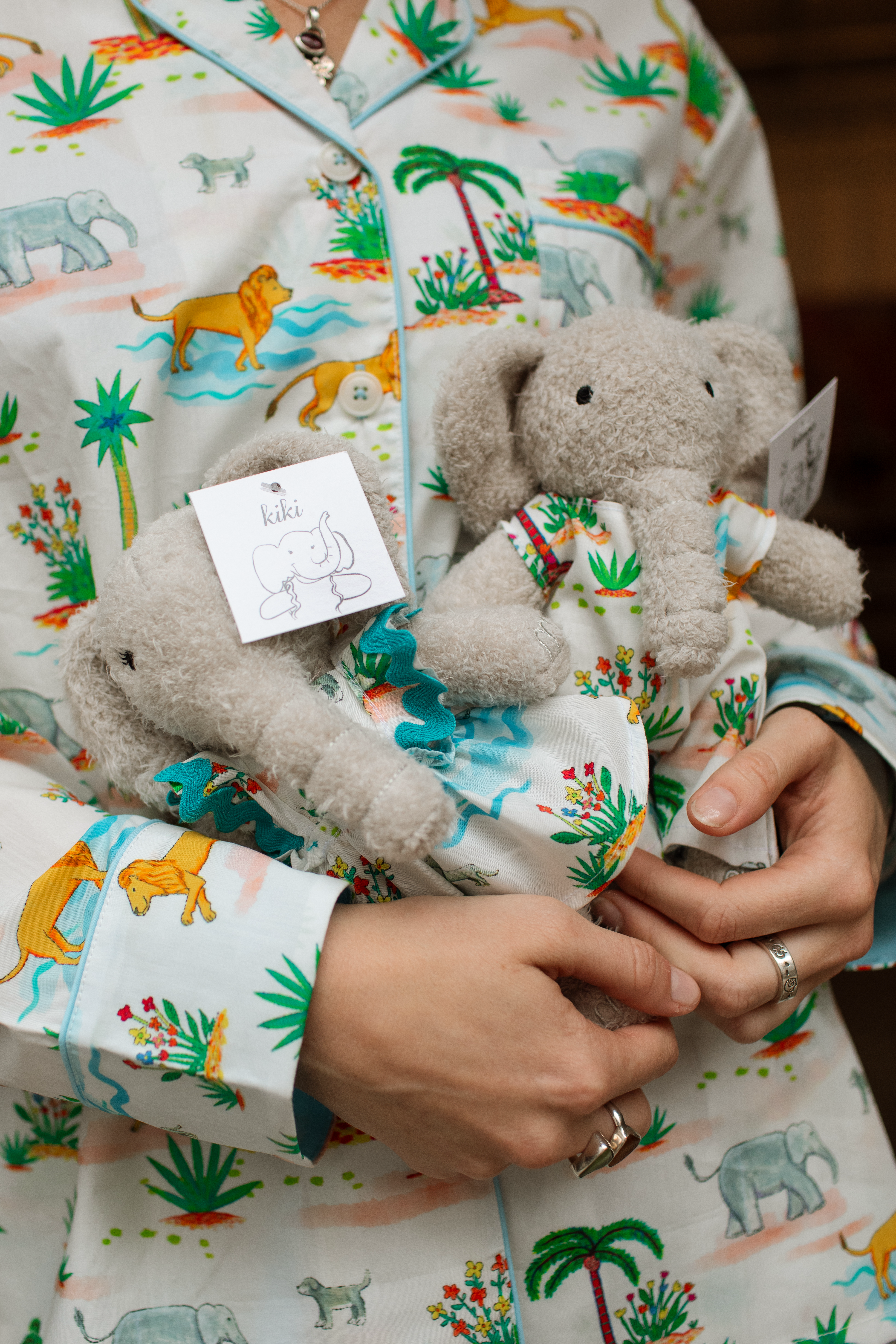 Child in pajamas holding toy elephant with matching pajamas
