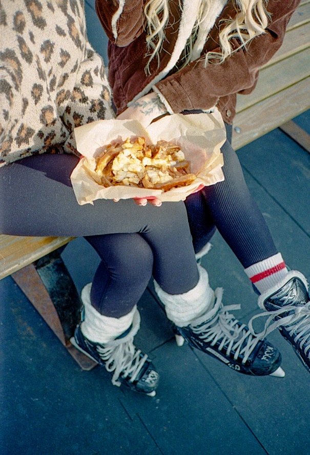 Two people eating poutine made with 1964 infused gravy