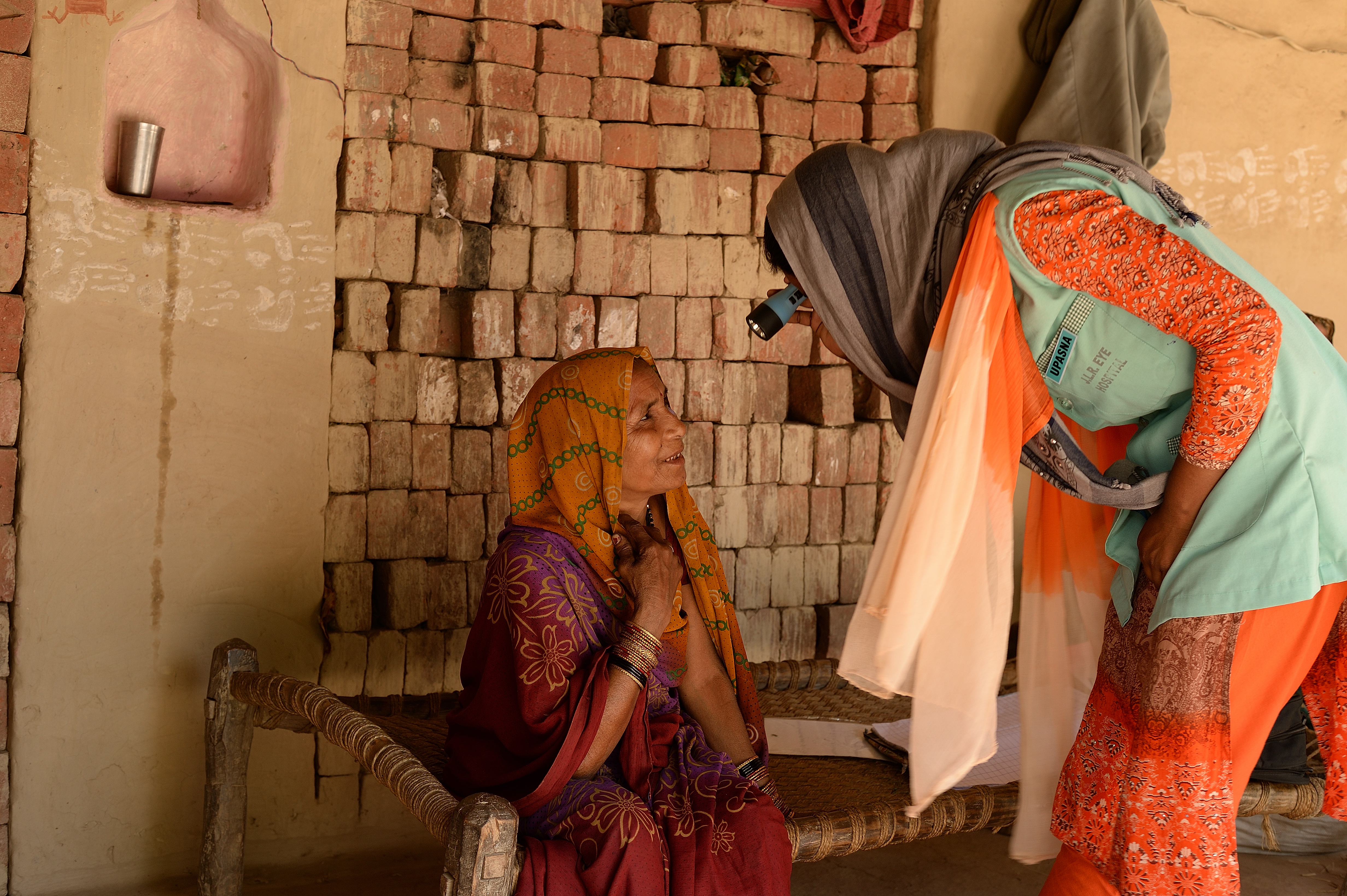 Community health worker screens a woman in India for eye health issues 