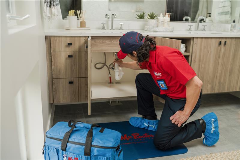 Plumber fixing kitchen drain to avoid blockages and clogs