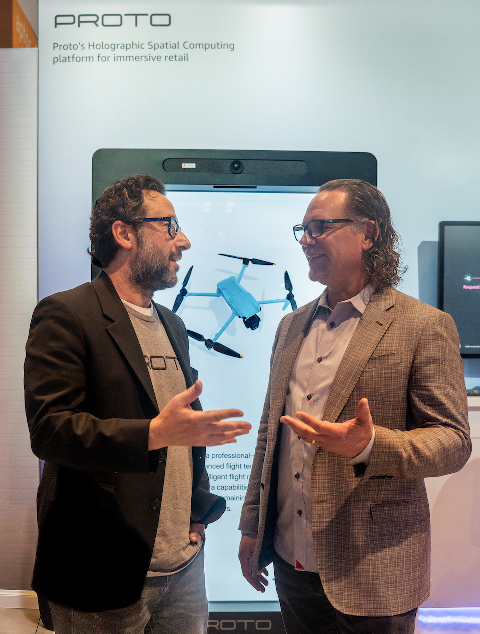 Founder and Chairman David Nussbaum (left) and CEO Todd Bouman demonstrate Proto's AI Hologram tools for retail at NRF 2025. (Photo: Eli Edwards)