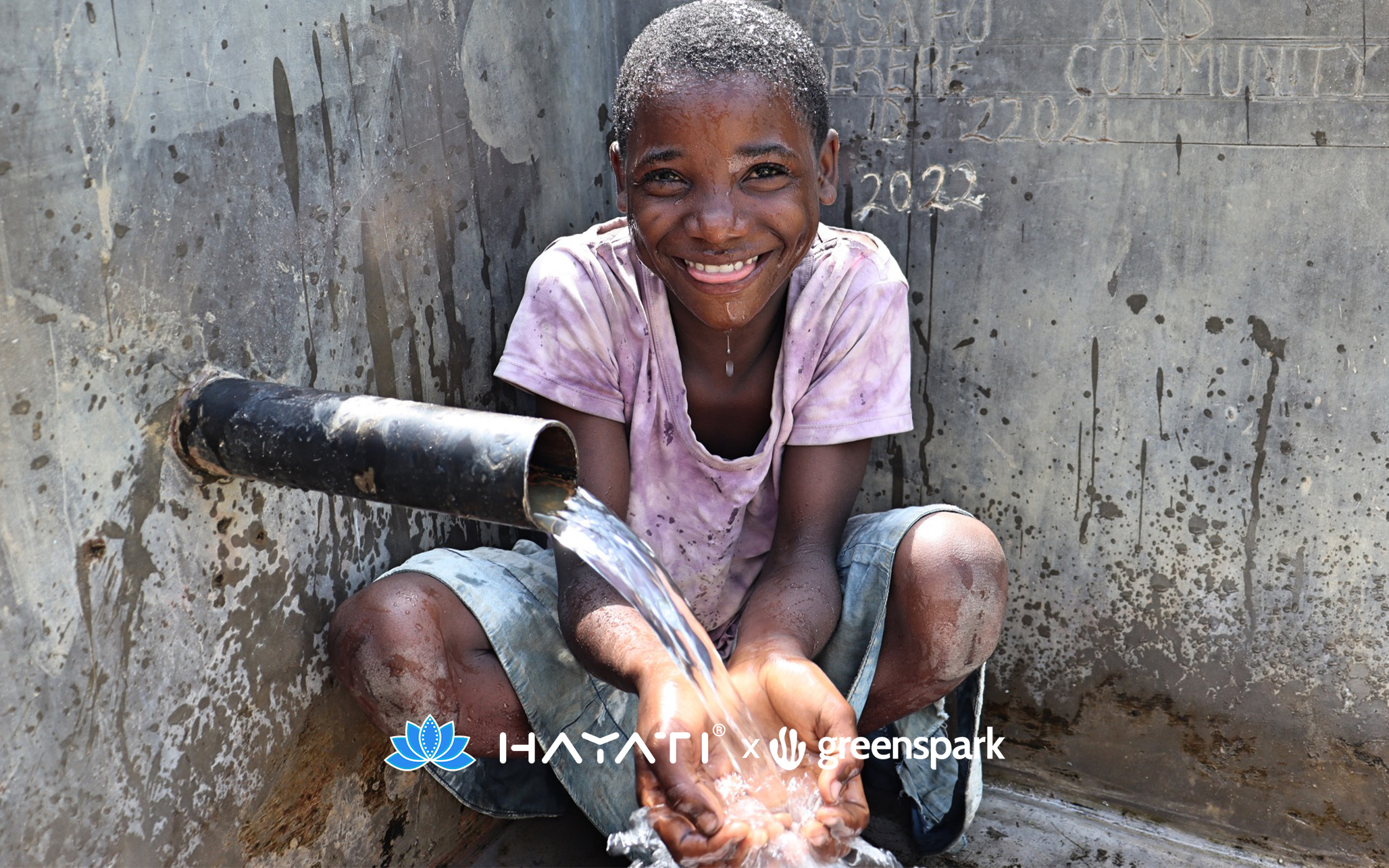 Child collecting clean drinking water from a community water pipe supported by Hayati For Nature initiative
