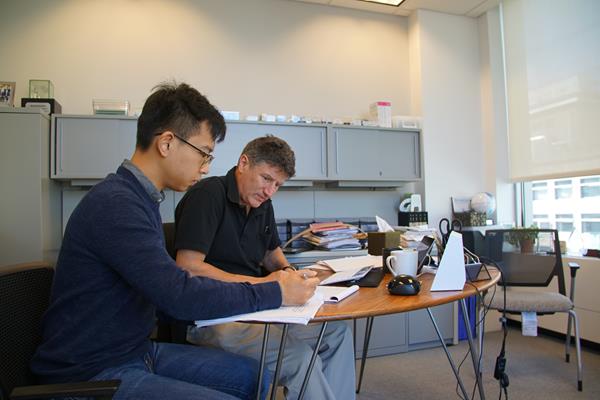 Student Wencai Zheng works with Professor Peter Carr, chair of NYU Tandon's Department of Finance and Risk Engineering. Small class sizes, career placement success, the number of Wall Street practitioners offering their expertise to students, and coursework in emerging fields such as blockchain and machine learning have raised the visibility and rankings of the graduate program for quantitative finance.