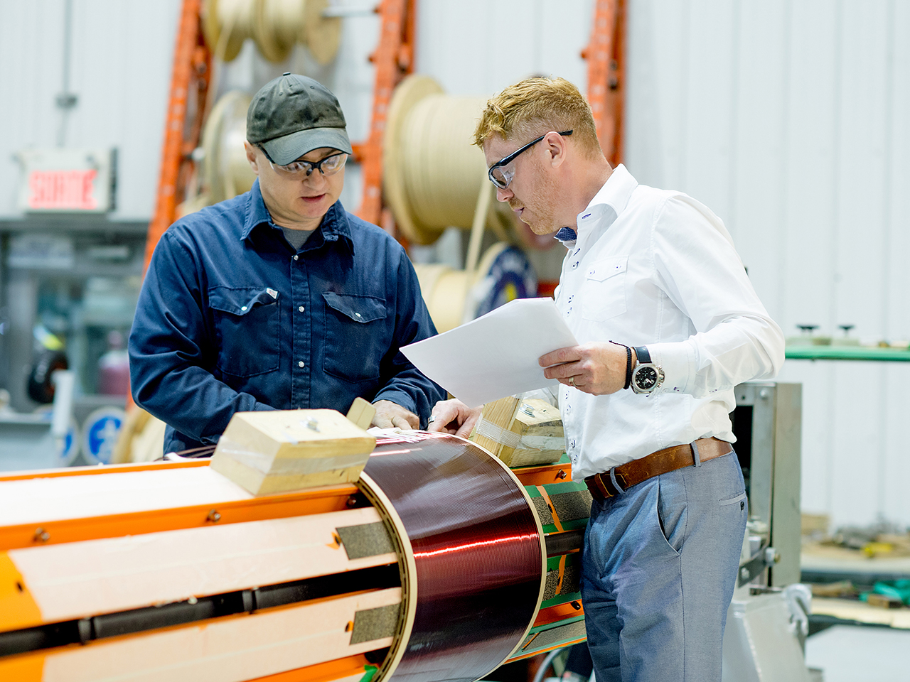 IPS team members work together to assemble the windings for a transformer.