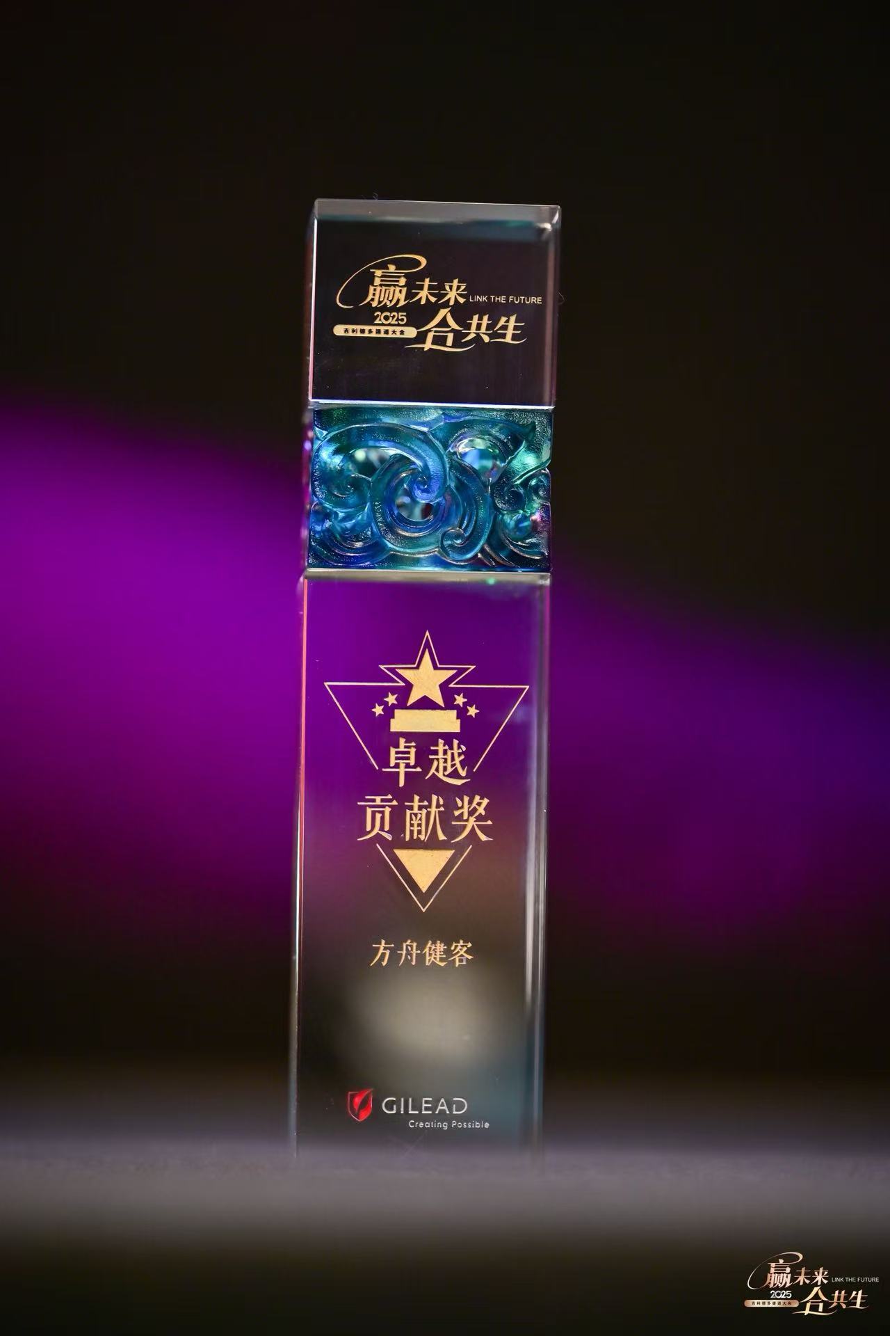 A transparent crystal trophy with golden text and patterns set against a dark background with purple lighting.