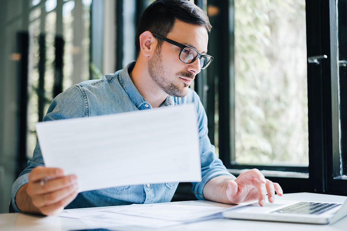 Tax Professional Reviewing Documents on Laptop