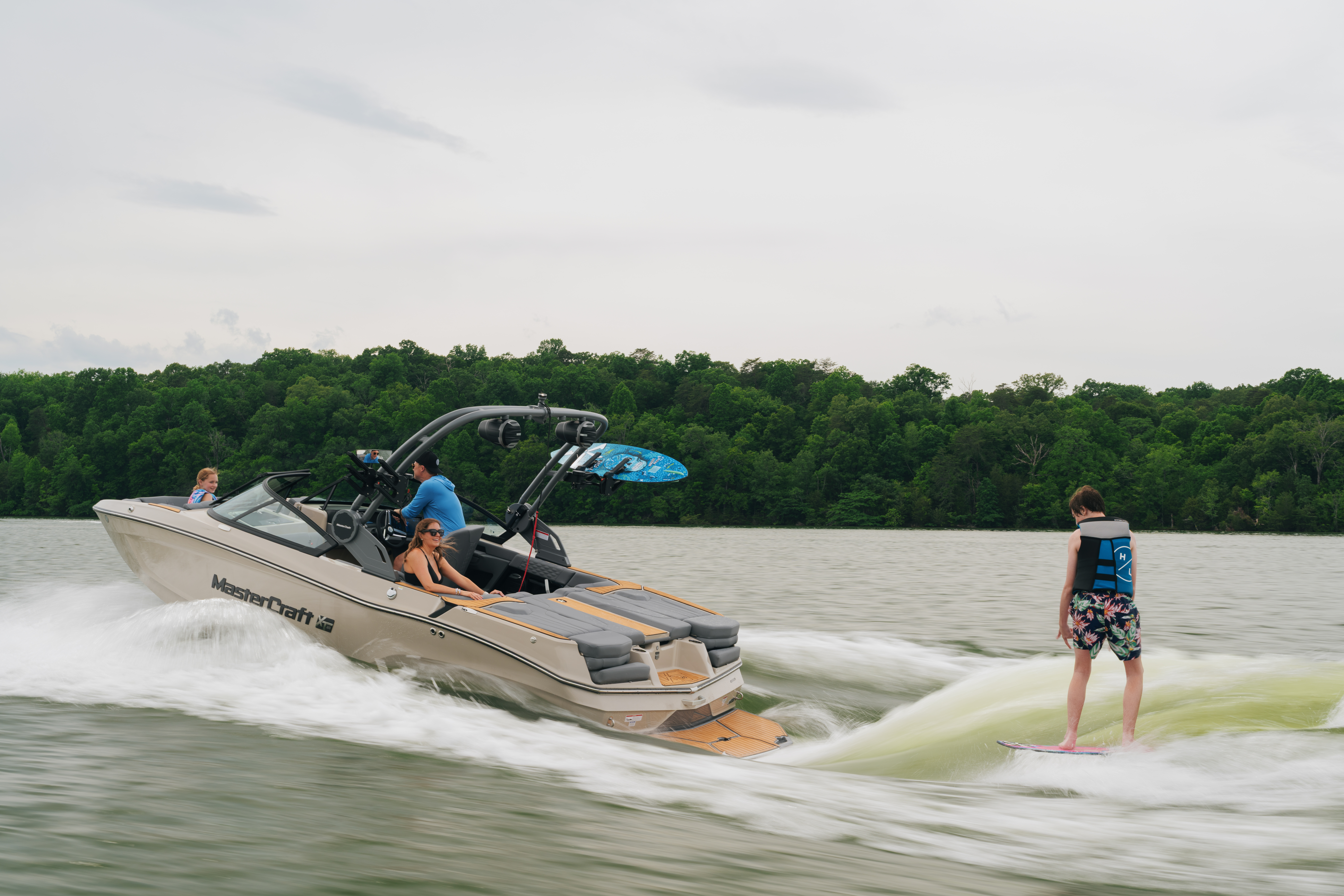 MasterCraft boat towing a wakesurfer on a calm lake, demonstrating safe and responsible boating practices.