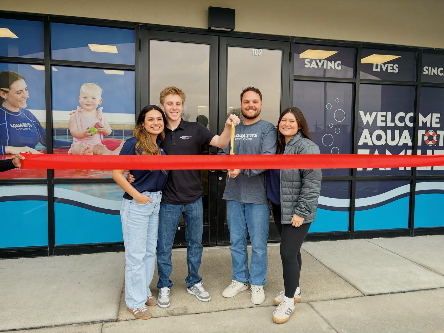 The owners of Aqua-Tots West Omaha gather for a ribbon cutting outside their new school. From left to right: Daniella Hernandez, Luke Sciarro, Spencer Preston and Mady Preston.