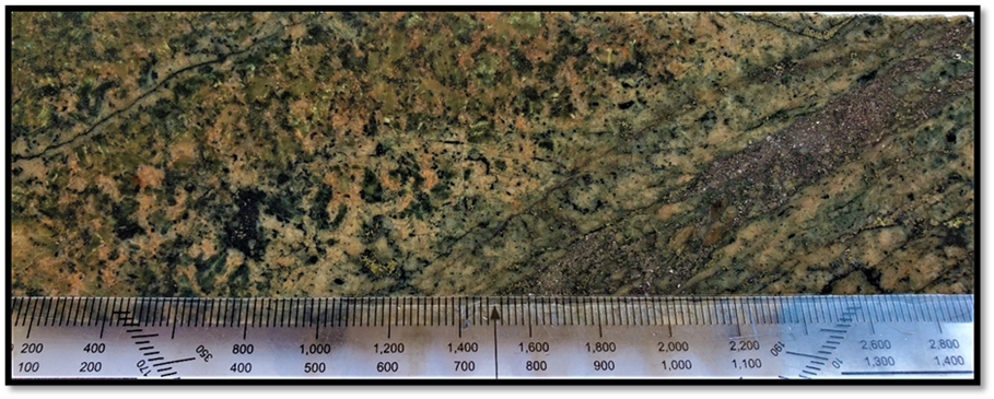 Quartz-arsenopyrite-pyrite-chalcopyrite vein with sericite altered margins cutting monzonite within TH21-11 @83.00m. Sample# 41958 containing 0.19% Cu, 0.20g/t Au, 0.92g/t Ag and 13.70ppm Mo over 0.50m.