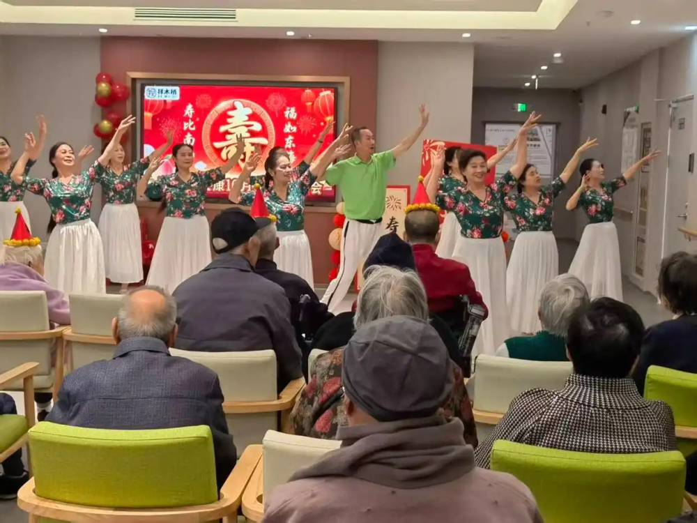 The image shows a dance team performing for the elderly at the Zemuqi Wellness Center in Chengdu